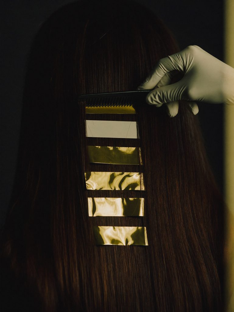 Stylist sectioning hair during a color correction